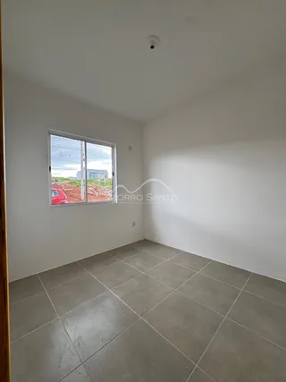 Vista interna de um cômodo com piso de cerâmica e janela.