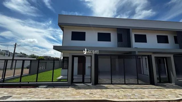 Fachada de uma residência moderna em Lajeado, Brasil, com cerca de metal na frente.