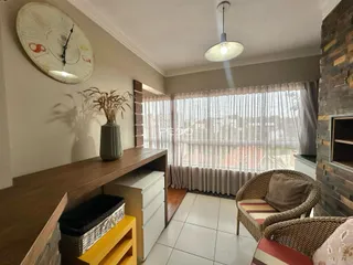 Sala de estar com janela e móveis de madeira.