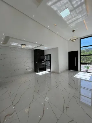 Sala de estar com piso de mármore claro e iluminação natural.