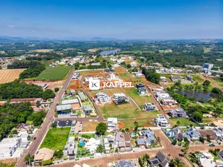Vista aérea de um loteamento residencial com casas e áreas verdes em Lajeado, Brasil.