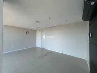 Espaço interno amplo com piso claro e paredes brancas.