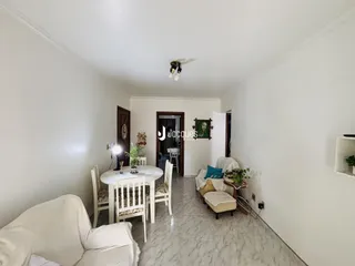 Ambiente interno de uma sala com mesa de jantar e sofá em Lajeado.