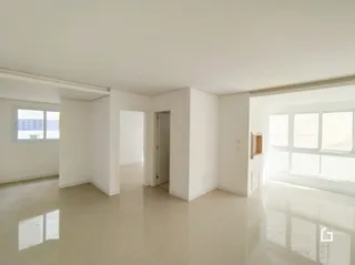 Interior de um ambiente claro com paredes brancas e piso claro.