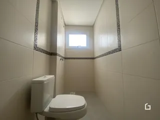 Foto de um banheiro com revestimento cerâmico nas paredes.