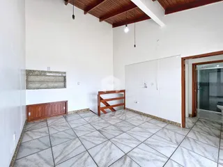 Interior de uma sala com piso de cerâmica e paredes brancas.