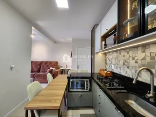 Ambiente de sala de estar e cozinha em um imóvel no Brasil.