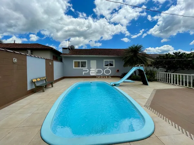 Foto de uma piscina com escorrega em uma propriedade em Lajeado.