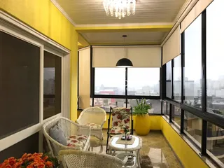 Sala de estar com grandes janelas que oferecem vista da cidade.