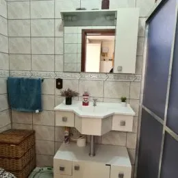 Foto de uma área de cozinha com bancada branca e revestimento de azulejos.