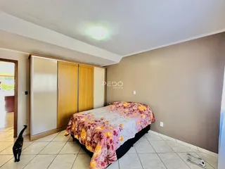 Quarto com cama e armário de madeira em um imóvel no Brasil.