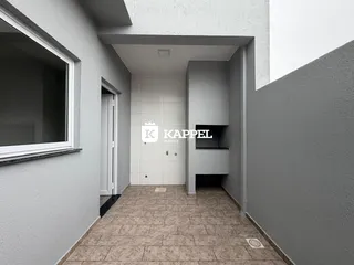Hall de entrada com piso de cerâmica e paredes brancas.
