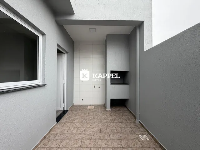 Hall de entrada com piso de cerâmica e paredes brancas.