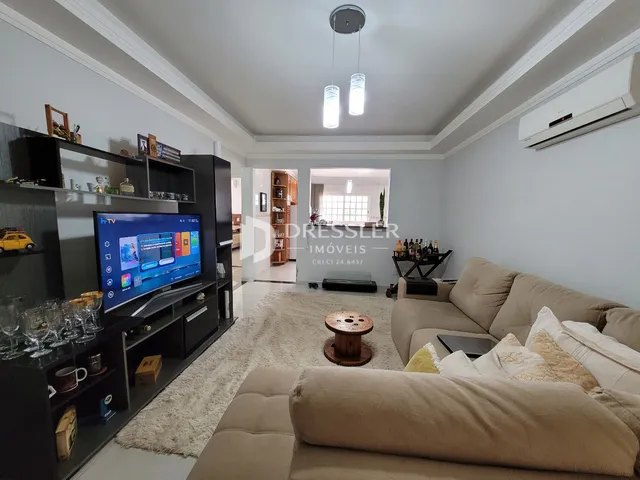 Sala de estar com sofá e televisão em um imóvel no Brasil.