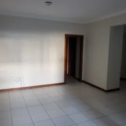 Interior de um cômodo com piso de cerâmica e paredes brancas.