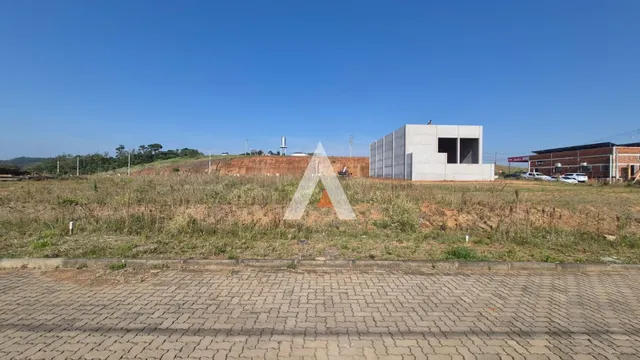 Vista externa de uma construção em terreno com vegetação seca.