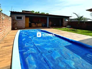 Foto de uma piscina externa em um imóvel com deck de madeira.