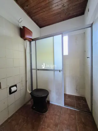 A foto mostra o interior de um banheiro com piso de cerâmica e paredes brancas.