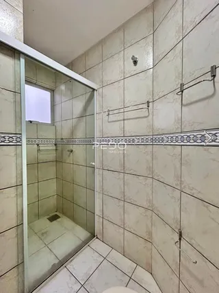Interior de um banheiro com revestimento de azulejos claros.