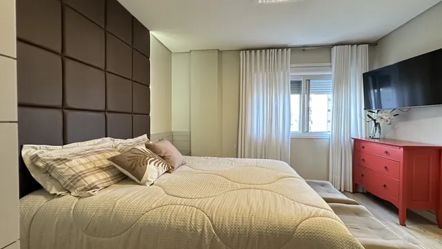 Quarto com cama e televisão em um apartamento.