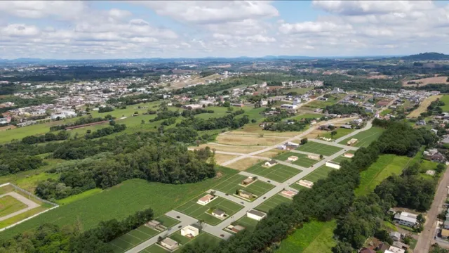 Vista aérea de uma área residencial com campos verdes e estradas no interior de Lajeado.
