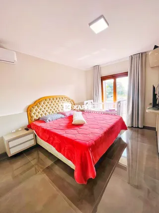Um quarto com cama de casal e cabeceira amarela.