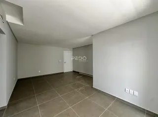 Corredor interno com paredes brancas e piso de cerâmica.