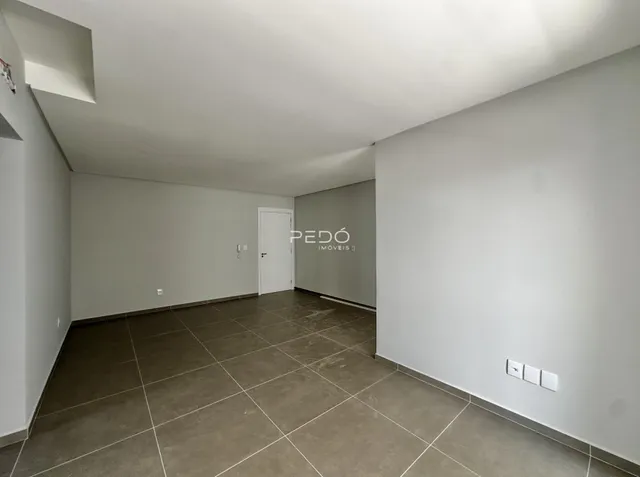 Corredor interno com paredes brancas e piso de cerâmica.