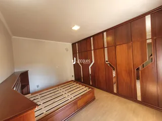 Quarto com cama de madeira e armários em madeira.
