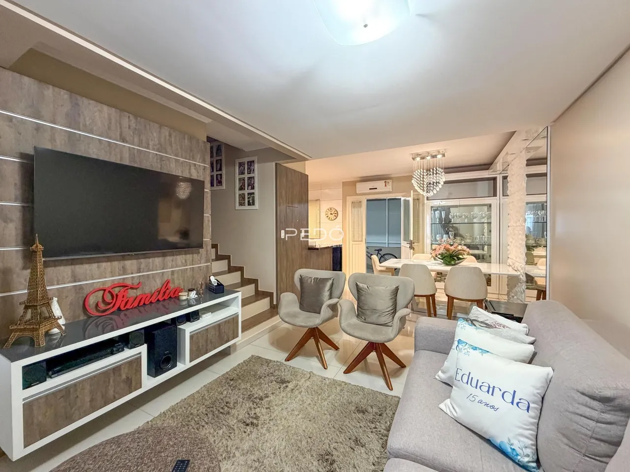 Sala de estar com sofá e televisão em um apartamento no Brasil.