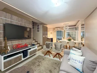 Sala de estar com sofá e televisão em um apartamento no Brasil.
