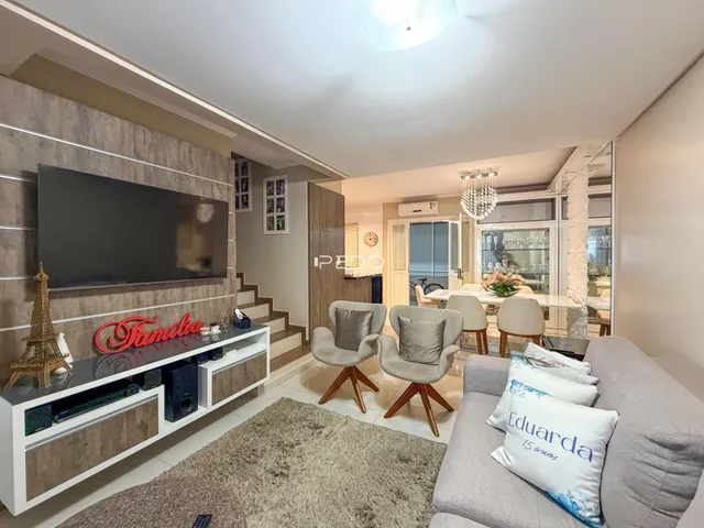 Sala de estar com sofá e televisão em um apartamento no Brasil.