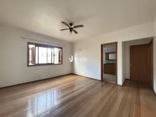 Sala de estar com piso de madeira clara e janela.