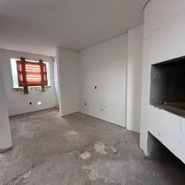 Foto de um ambiente interno vazio com piso de concreto.