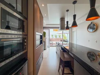 Vista da cozinha moderna com piso claro e iluminação contemporânea.