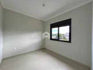 Ambiente interno de uma sala com piso claro e paredes brancas.