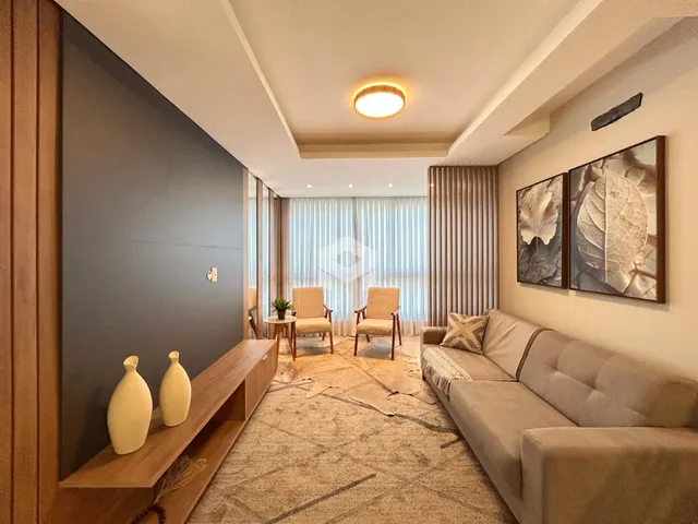 Sala de estar com decoração moderna e piso de madeira clara.