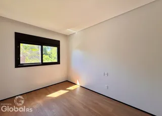 Quarto com piso de madeira e janela.