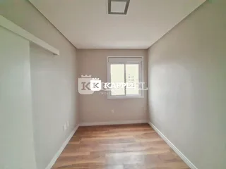 Foto de um ambiente interno com piso de madeira e paredes claras.