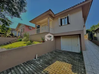 Fachada de uma casa em Lajeado, Brasil, com varanda e área externa pavimentada.