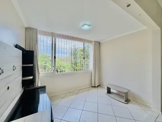 Interior de uma sala com piso de cerâmica e grande janela.