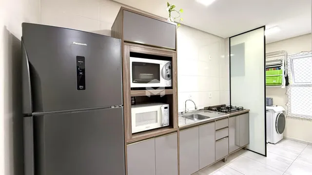 Foto de uma cozinha moderna com geladeira e armários em madeira.