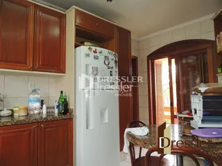 Foto de uma cozinha com armários de madeira e geladeira branca.