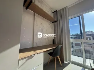 Foto de um interior mostrando uma bancada de madeira e uma grande janela.