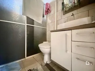 Foto de um banheiro com azulejos brancos e bancada de madeira.