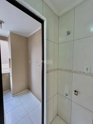 Vista de um banheiro adjacente a uma sala com piso de cerâmica.