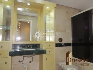 Detalhe da bancada e espelho de um banheiro em imóvel à venda.