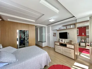 Quarto com cama e armários em madeira clara.