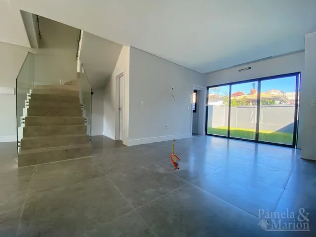 Ambiente interno com escadaria e portas de vidro em um imóvel em Lajeado.