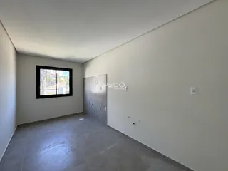 Ambiente interno com piso de cerâmica e porta de madeira em uma residência.